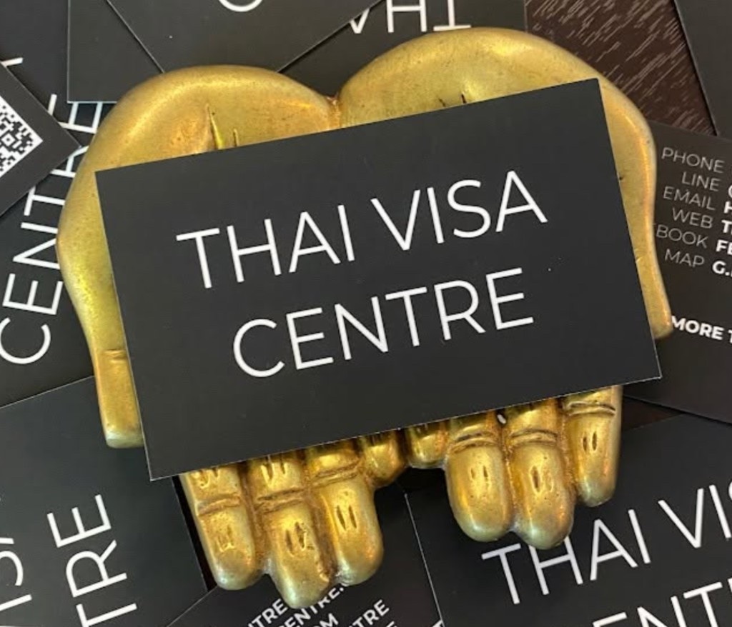 Thai Visa Centre business cards on a gold hand sculpture